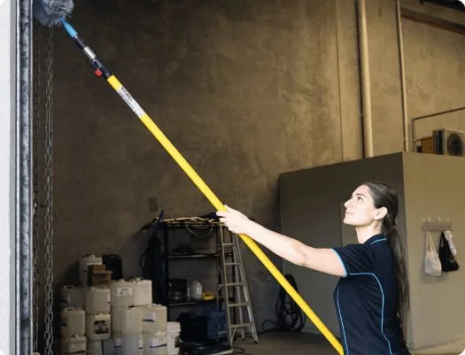 Female commercial cleaner cleaning a warehouse